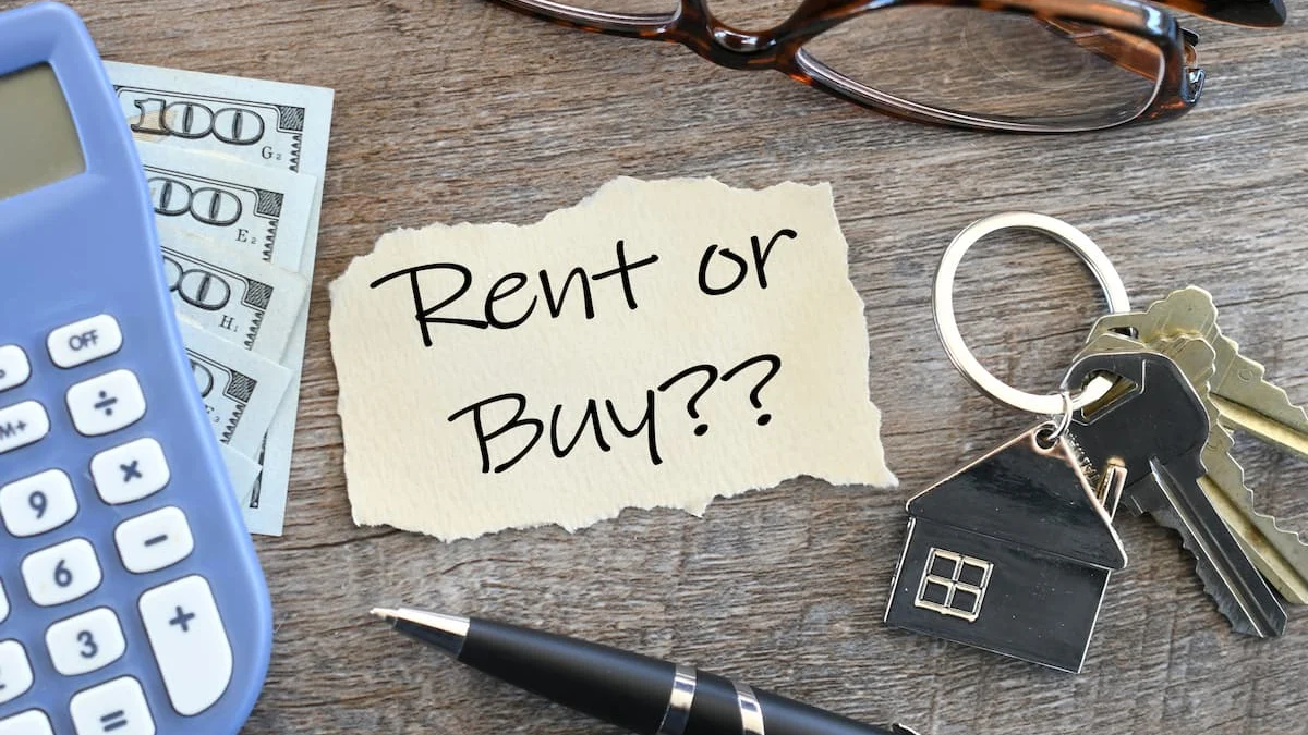 Nota con la pregunta “Rent or Buy?” junto a una calculadora, dinero y llaves de vivienda