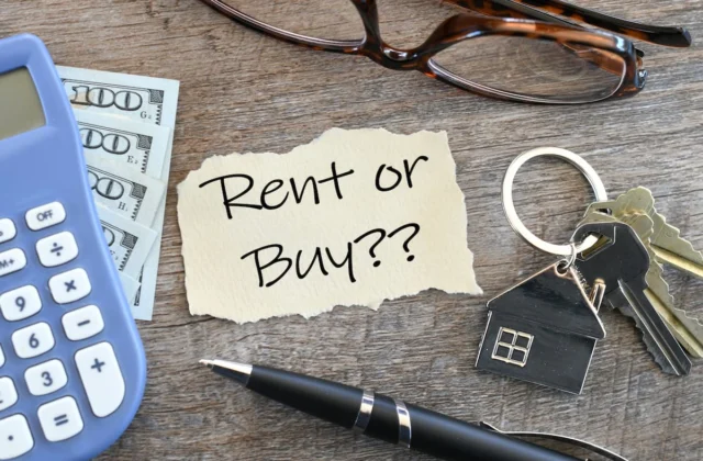 Nota con la pregunta “Rent or Buy?” junto a una calculadora, dinero y llaves de vivienda