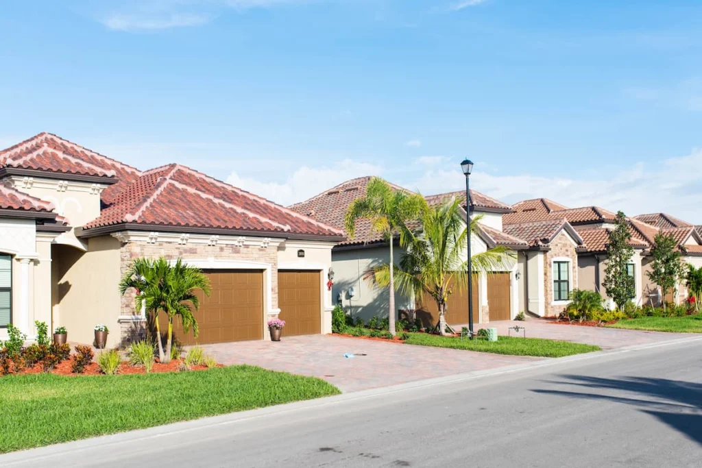 Conjunto de casas unifamiliares con jardines, garajes y palmeras en una comunidad residencial de Florida