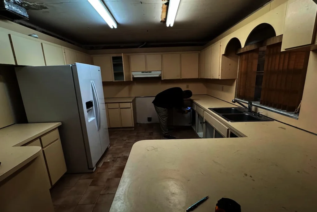 Cocina antigua con gabinetes y encimeras existentes durante los trabajos previos a una remodelación