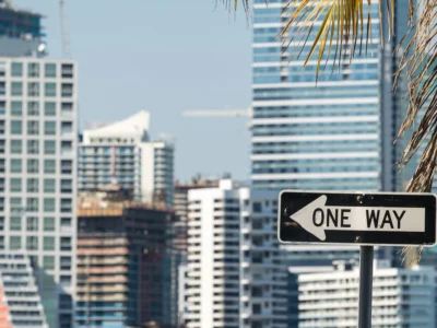 Señal de tránsito “ONE WAY” frente a edificios altos en una zona urbana