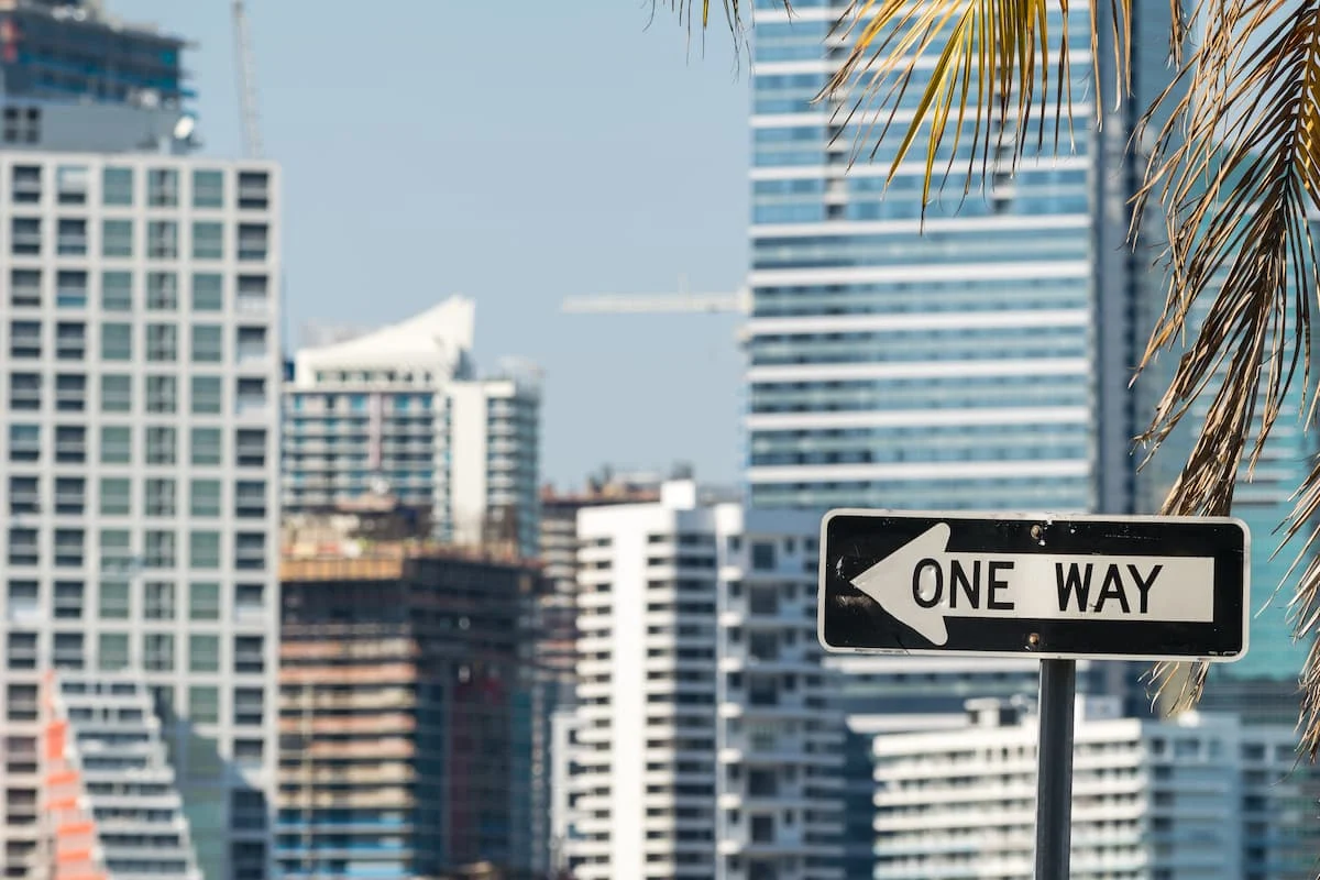 Señal de tránsito “ONE WAY” frente a edificios altos en una zona urbana