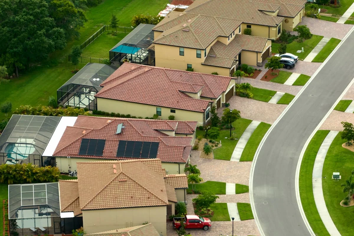 Vista aérea de una comunidad residencial de Florida con casas unifamiliares, piscinas, jardines y calles internas